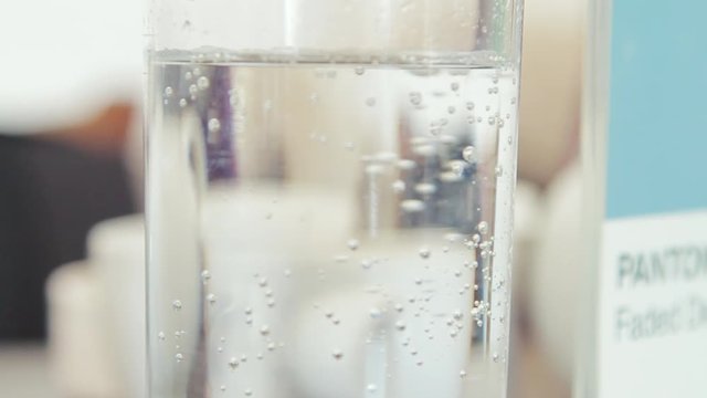 Air Bubbles Rise to the brim of a glass of sparkling water