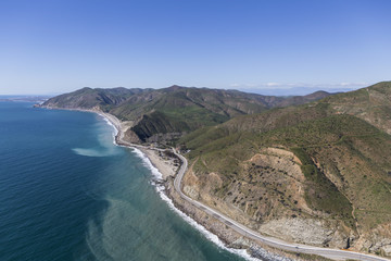 Aerial of Pacific Coast Highway winding past Sycamore Cove State Park north of Malibu in Southern California.  