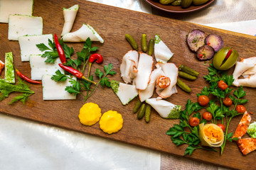 Salo with cucumbers and pepper on a wooden board. Traditional Ukrainian food