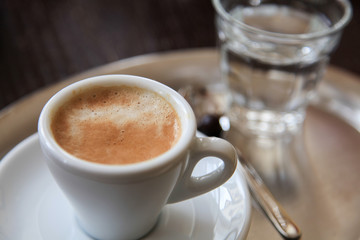Eine Tasse Espresso und ein Glas Wasser