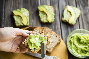 spread with a knife on a paste of avocado bread Greceanii. raw and healthy food for vegan - obrazy, fototapety, plakaty