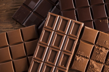 Dark homemade chocolate bars and cocoa pod on wooden