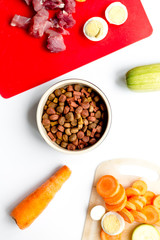 healthy dogfood with eggs, vegetables and meat on kitchen background top view