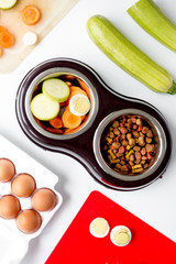 petfood set with vegetables and eggs on kitchen table background top view