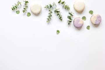 Trendy design with macaroons and flowers on white background top view mockup