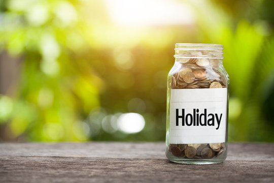 Holiday word with coin in glass jar with Savings and financial investment concept.
