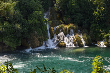 Small waterfalls or cascade and a pond at the Krka National Park in Croatia, on a sunny day.