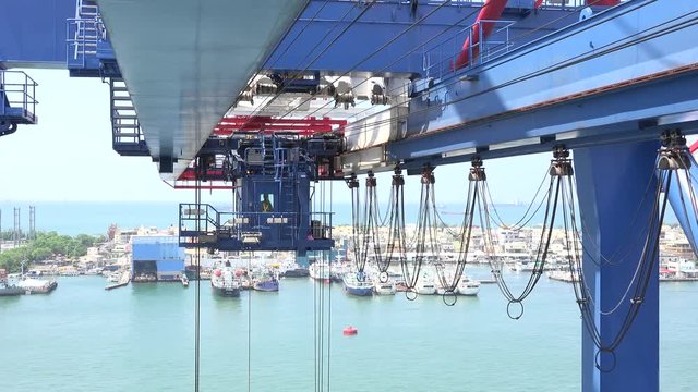 The spreader of a gantry crane is moving in the Port of Kaohsiung the largest harbor in Taiwan that has an annual handling capacity 10 million containers. 4K