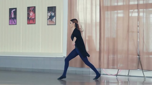 Graceful girl training ballet poses in dance studio. Slowly