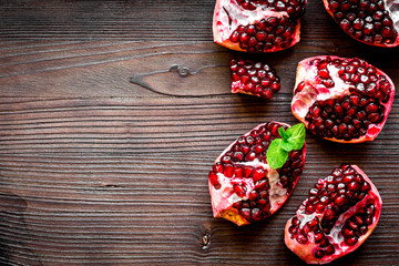 sliced pomegranate on wooden background top view