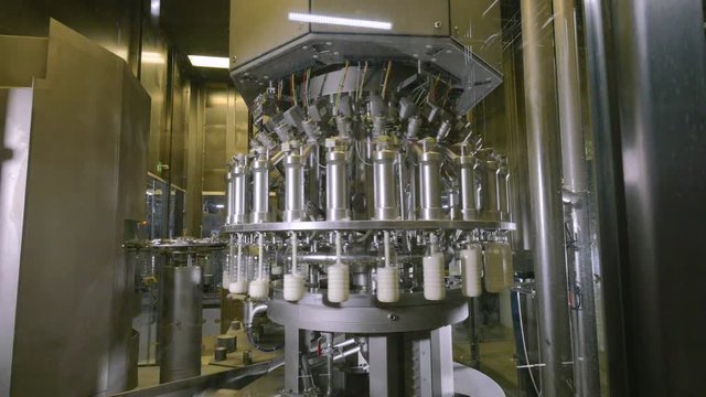 Fresh milk poured into bottles on a automated production line. 4K.