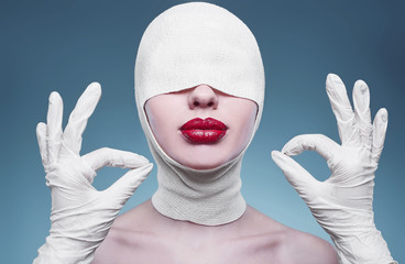 Young fashion woman with bandaged head and nurse hands