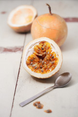 Passion fruits and slice with  spoon on wooden background