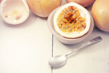 Passion fruits and slice with  spoon on wooden background