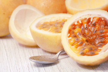 Passion fruits and slice with  spoon on wooden background