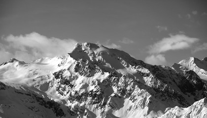 Fototapeta na wymiar Black and white view on snowy mountains at sun day