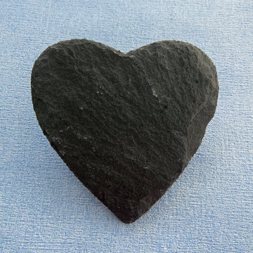 Black Slate heart shape on a blue background with room for text on the slate