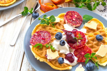 Belgium waffles with blueberry, blood orange, whipped cream. Breakfast