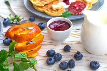 Belgium waffles with blueberry, blood orange, whipped cream. Breakfast
