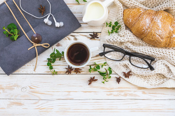 Croissant, coffee, headphones and notebook. Workplace and Leisure concept