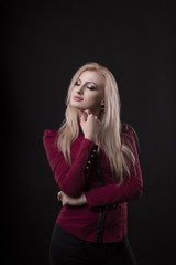 Fototapeta premium Pretty woman dressed in red blouse posing at studio