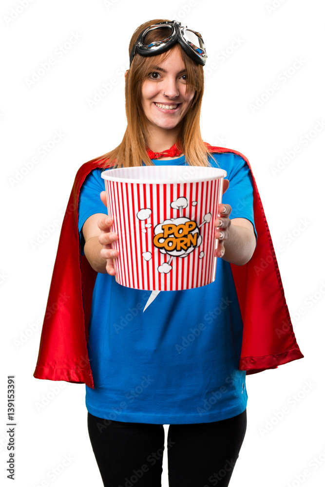 Wall mural Pretty superhero girl eating popcorns