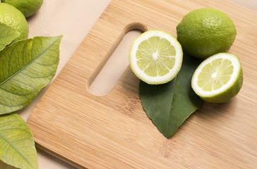 Fresh Green Lemons in a Chopping board