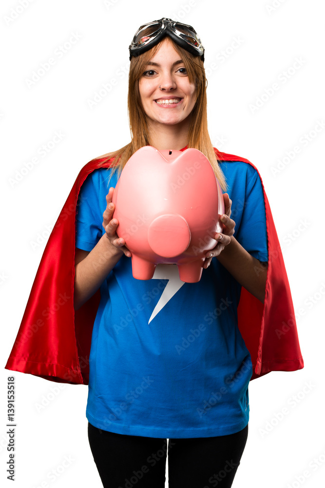 Wall mural Pretty superhero girl holding a piggybank