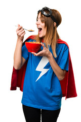 Pretty superhero girl eating cereals from a bowl © luismolinero