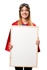 Pretty superhero girl holding an empty placard © luismolinero