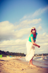 Woman on beach throwing sun hat
