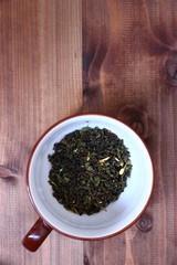 green tea leaves in cup wood background