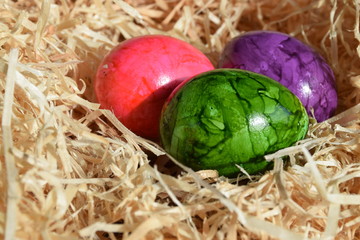 Bunte Eier im Korb mit Holzwolle