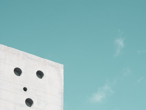 Corner of white building against blue sky