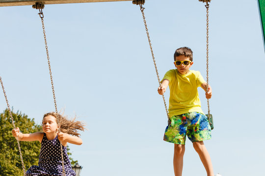 Two children having fun on swingset.