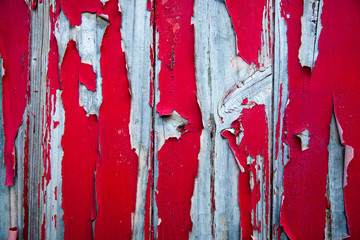 Peeling red paint on silvered wood