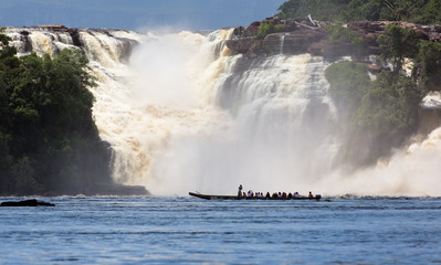 Golondrina waterfall and tourists boat in the lagoon of Canaima national park - Venezuela