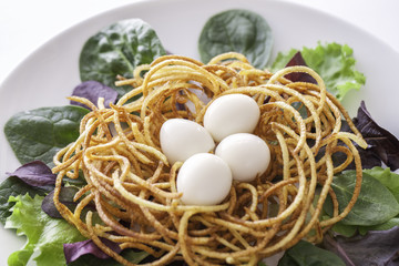 Ethical vegetarian meal. Free range quail eggs in spiralized potato nest. Healthy organic lettuce...