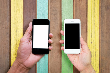 Man and woman hand holding and using mobile,cell phone,smart phone with isolated screen on painted planks and wooden planks for background.