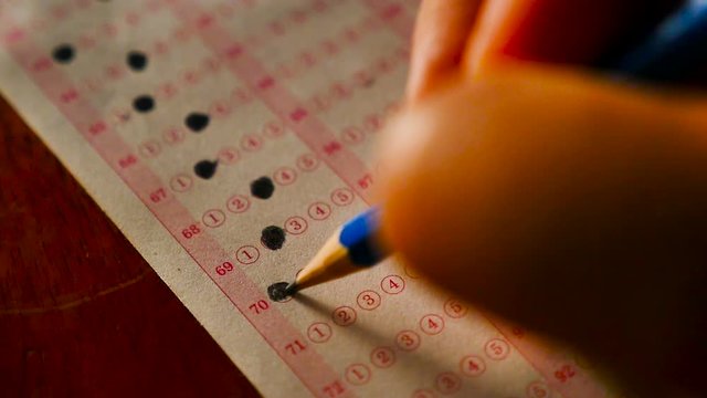 Close up student using pencil filling select choice on answer sheets slow motion shot
