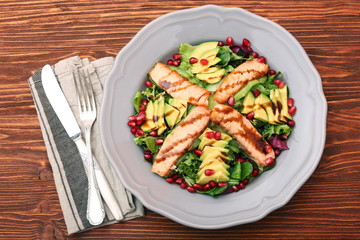 Salad with fried salmon, avocado and pomegranate seeds