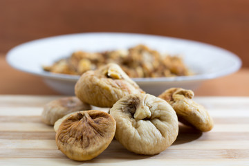 Dried fig and grapes on wooden plate