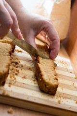 Female hands cutting and preparing cake crust