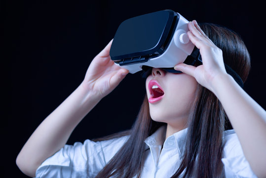 Asian Chinese young woman using vitual reality smart glasses in vitual space.low key photo