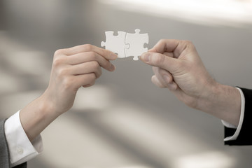 man and woman hand holding jigsaw puzzles