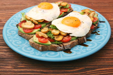 Sandwich with egg, tomato, greens, and mushrooms