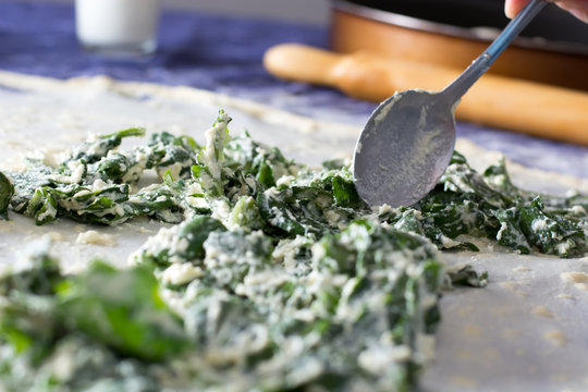 Homemade Phyllo or strudel dough with cheese and spinach on a home table cloth