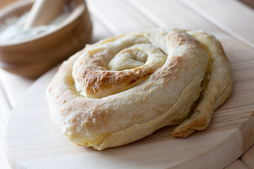 Freshly baked spiral cheese pie on the wooden plate