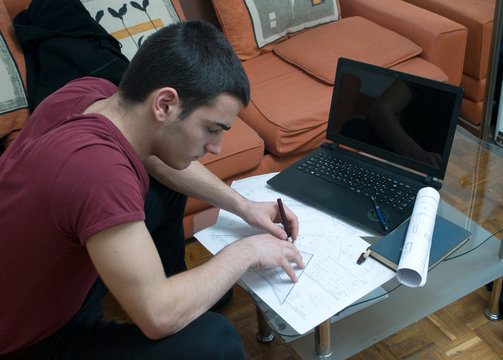 Photographing Danila Mazić in a tight red shirt and black pants while drawing construction plans, Novi Sad, Serbia