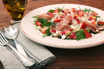 Arugula salad with strawberries, feta cheese, prosciutto, parmes